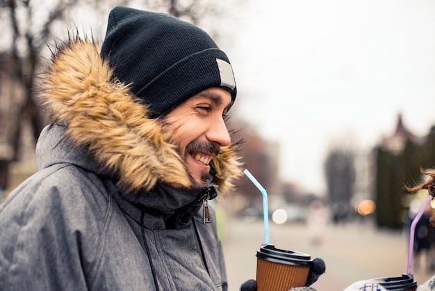 冬のフェアでカップルがホットコーヒーを飲む