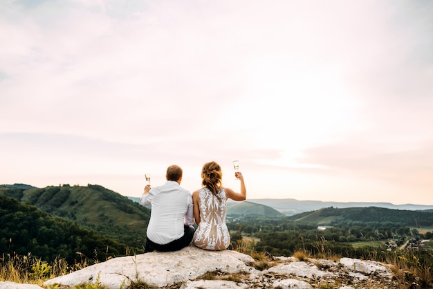 Photo couple drinking champagne on a mountain