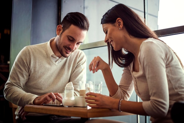 写真 コーヒーを飲みながらカフェでおしゃべりするカップル