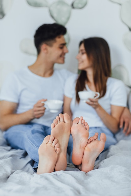 Couple drinking coffee in bed at home