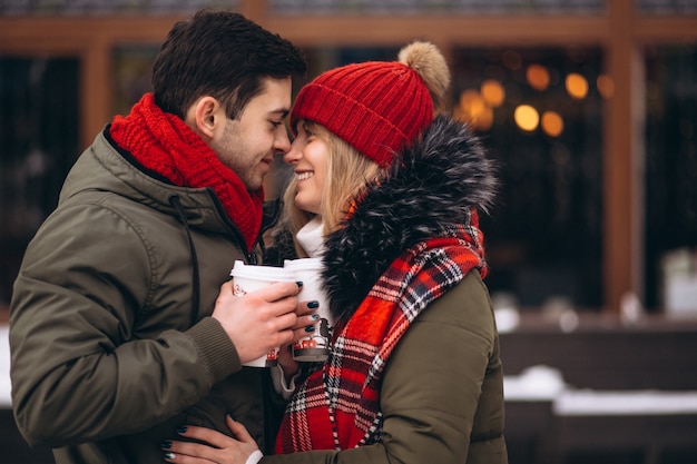 冬のカフェでコーヒーを飲むカップル