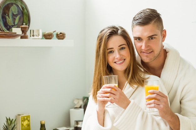 Couple drinking orange juice in bathrobes