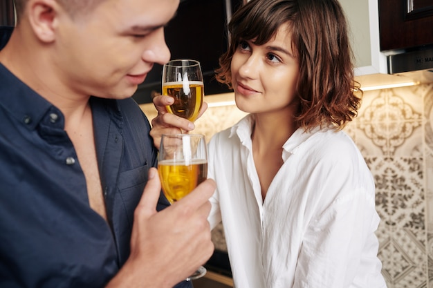 Couple drinking white wine in kitchen