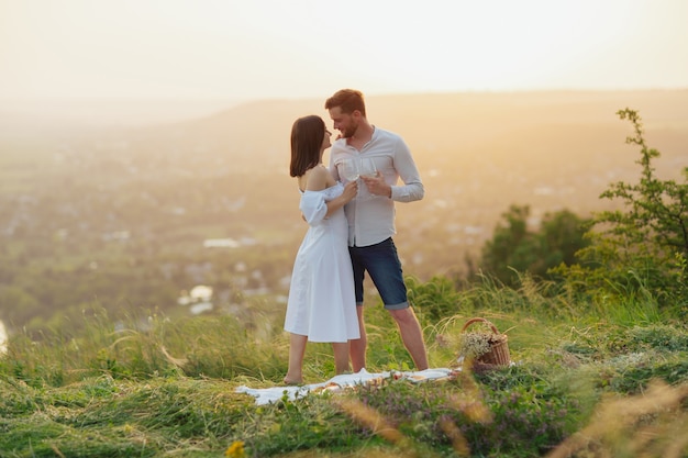 Coppia che beve vino a un picnic in un campo