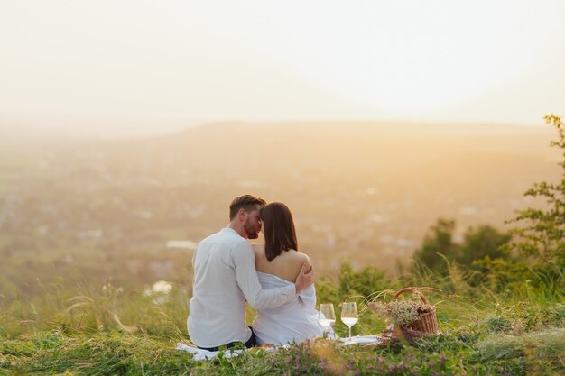 Couple drinking wine at a picnic in a field