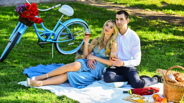 Coppia che beve vino giornata di sole coppia attraente che si gode un picnic romantico al tramonto in campagna coppia carina che beve vino insieme per sempre vero amore concetto romantico brindisi festeggia l'anniversario