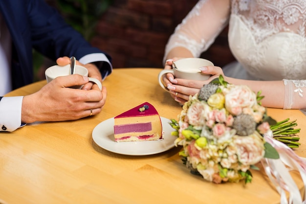 Couple drinks coffee with fruit cakes at a cafe