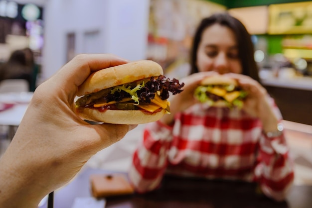 커플은 카페에서 치즈버거를 먹는다