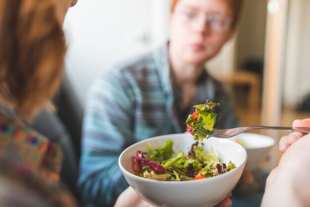 Foto coppia mangiare insalata sana a casa sul divano