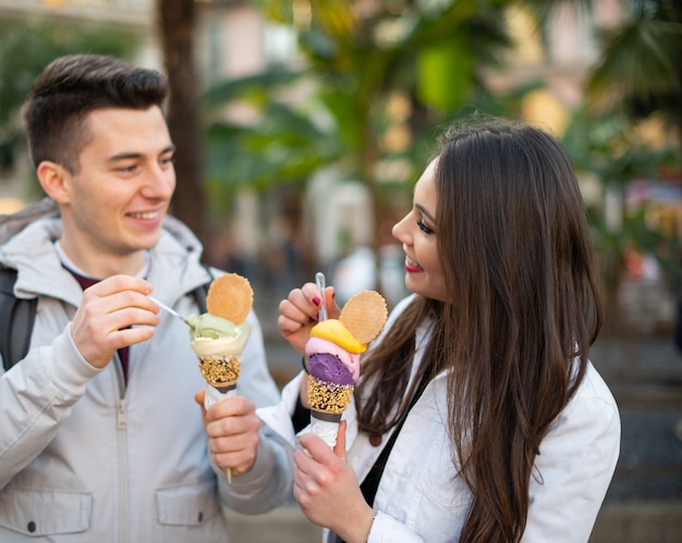 Coppia mangiare un gelato in una strada cittadina