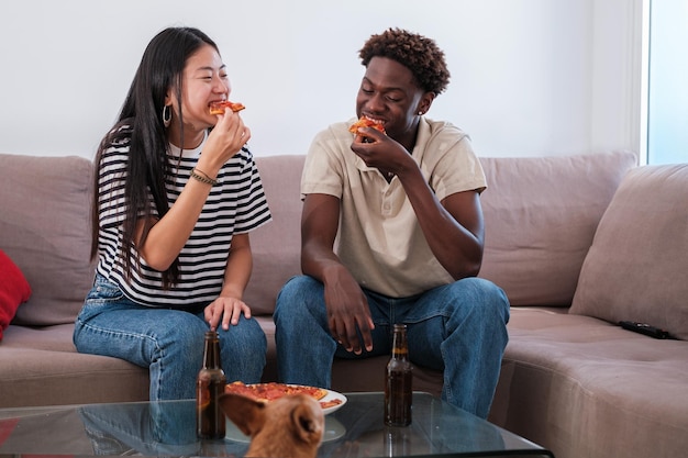 Couple eating a pizza in their living room and drinking a beer Concept lifestyle together fast food