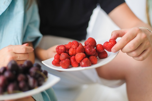 Couple eating strawberries and cherries