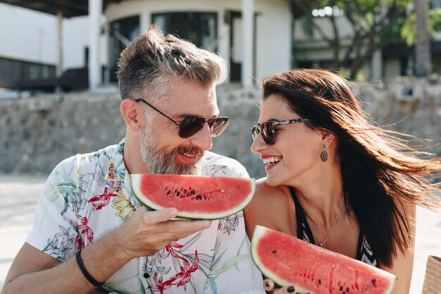 Couple eating watermelon at the beach