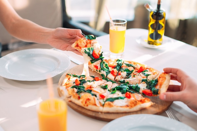 A couple eats pizza in a restaurant