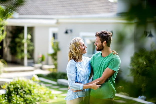 Couple embracing against house