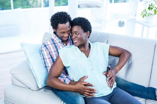 Photo couple embracing while sitting on couch