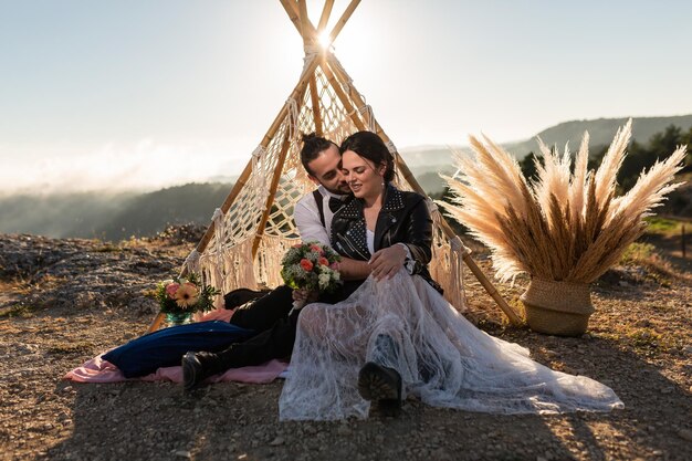 Photo couple embracing while sitting outdoors