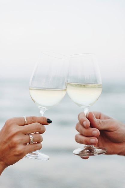 ビーチでワインのグラスを楽しむカップル