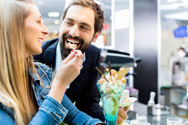 Couple enjoying an ice cream sundae in cafe