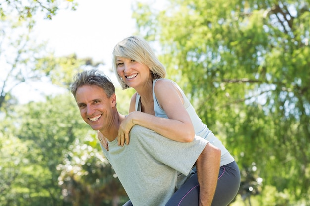 Couple enjoying piggyback ride in park