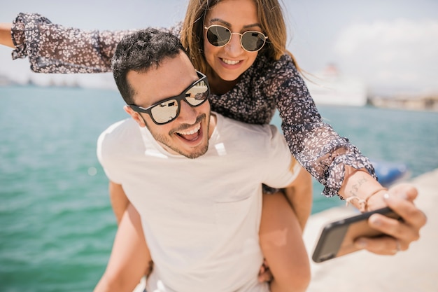 Couple enjoying taking self portrait on cell phone