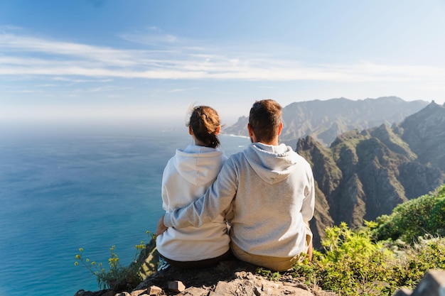 自然の中で休暇を楽しむカップル美しい沿岸風景を眺めるハイカー
