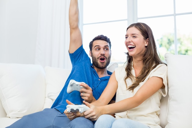 Couple enjoying video game on sofa 