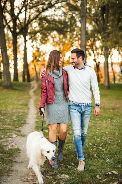 Couple enjoying walking the dog in the park