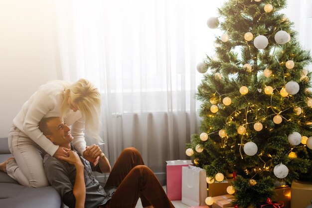 Couple Exchanging Christmas Gifts near Christmas tree.