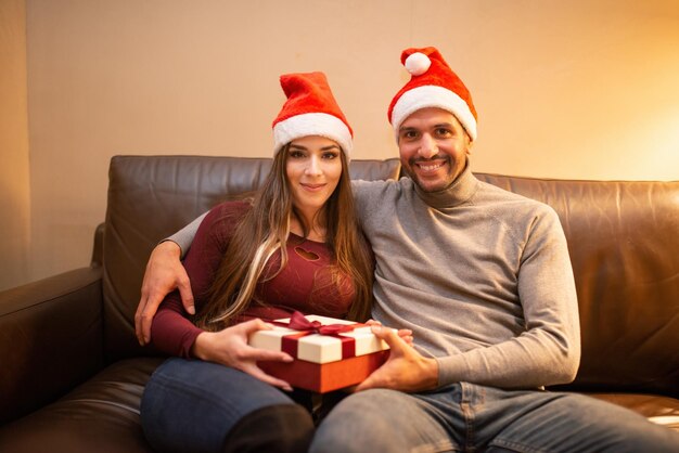 Couple exchanging Christmas presents at home