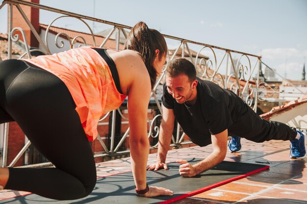 Photo a couple exercising on their rooftop