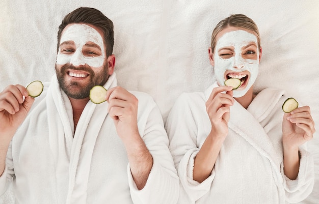 Couple facial and relax at spa for wellness skincare and love together with cucumber Happy portrait luxury body care or face detox mask in physical therapy for calm and zen beauty or health salon