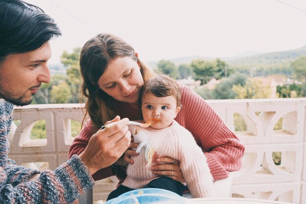 couple feeding daughter in balcony
