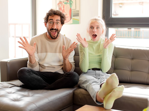 couple  feeling happy, excited, surprised or shocked, woman smiling and astonished at something unbelievable
