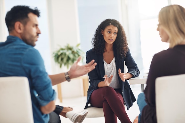 Couple fighting and arguing in therapy session with patient therapist helping inside office Female marriage counsellor working explaining and talking to angry frustrated and hurt married people