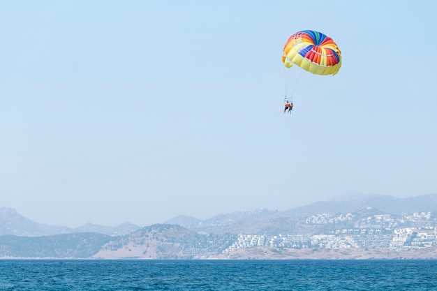 couple flying in a multicolored parachute hanging in the air