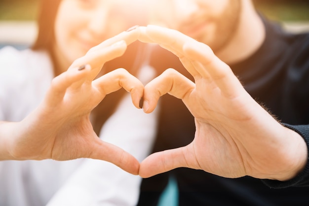 Couple forming heart with hands