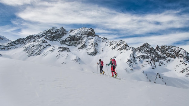 Couple of friends during a ski mountaineering excursion in the swiss alps