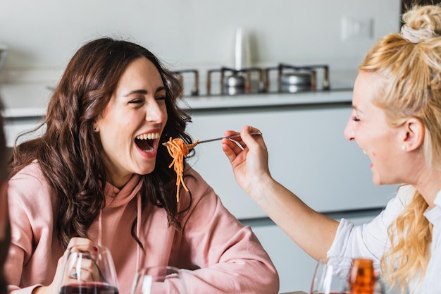 スパゲッティを食べて楽しんでいる友人のカップル