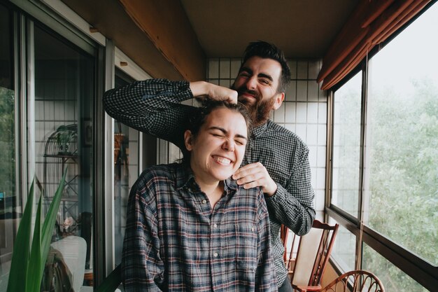 A couple of friends laughing and having fun on a very bright gallery during a sunny day