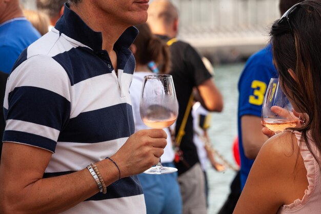 A couple of friends male and female holding a glass of Prosecco during an event