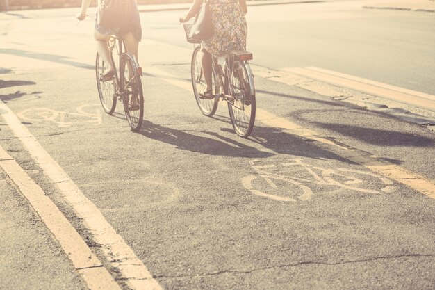 Couple of friends with bicycles on bike lane.