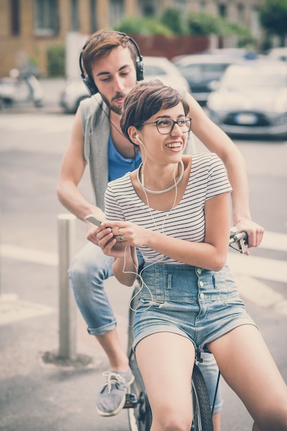 couple of friends young  man and woman riding bike