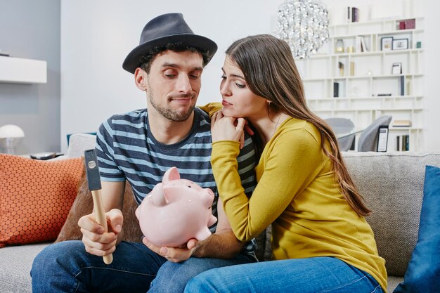 Photo couple in furniture store demolishing piggy bank