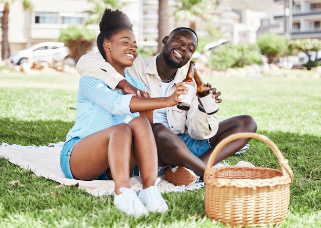 Couple on garden picnic date black woman and drink bottle of beer together young african man drinking alcohol and happy girl outdoor nature park in city and love relationship time together