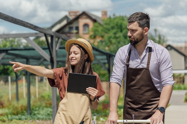 A couple of gardeners select plants for a customer at a garden center