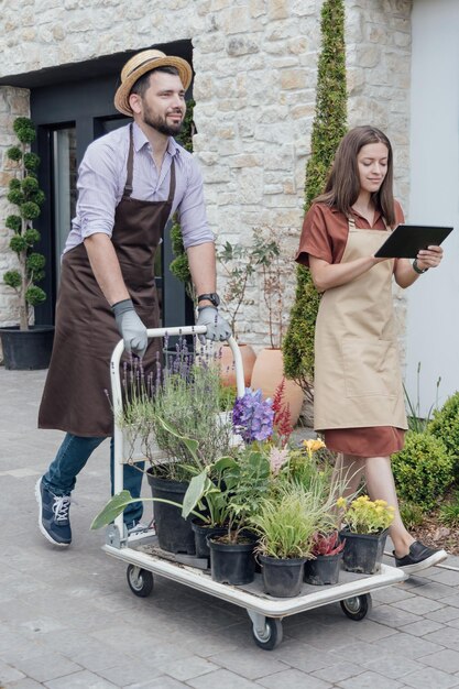 A couple of gardeners select plants for a customer at a garden center