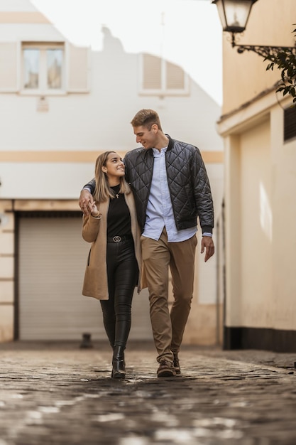 A couple gaze into each other39s eyes as they walk down an alley People