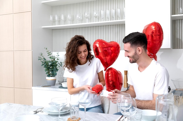 Photo a couple gives the presents to each other at the valentines day celebration