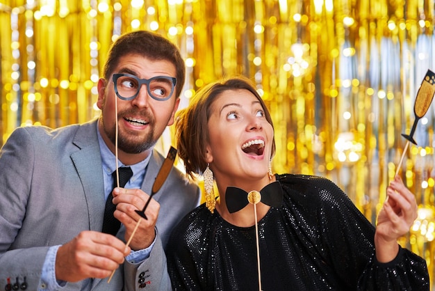 Photo couple over gold with photo booth accessories on party